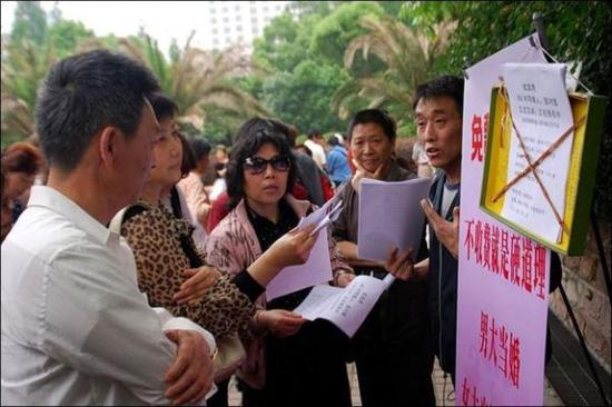 材料图：上海国民广场的“相亲角”，怙恃们忙着给孩子找工具。（BBC）