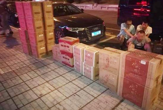 株洲警方查获的品牌假酒跟抓获的犯法怀疑人。法制晚报 图