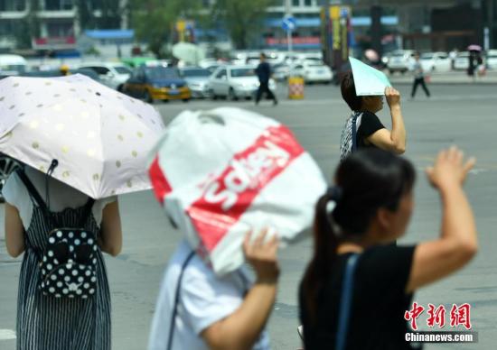 7月11日，河北石家庄大众低温中出行。该省景象台宣布低温白色预警旌旗灯号，受强暖气团影响，估计当日下战书，局部地域最高气温可达37-39℃，局地超越40℃。 中新社记者 翟羽佳 摄