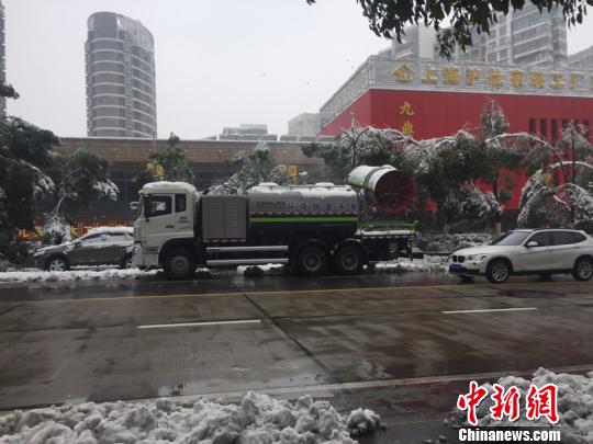 为除笼罩在年夜树上的雪，车辆拉着巨型的“吹风机”，给树木“洗剪吹”。　吴兰　摄